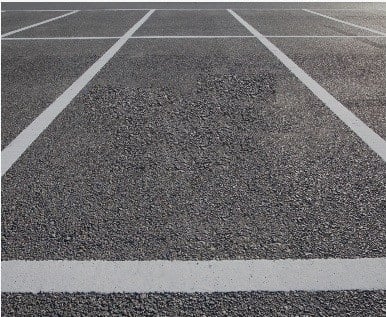 Freshly paved commercial parking lot with marked truck and trailer spaces in Long Island